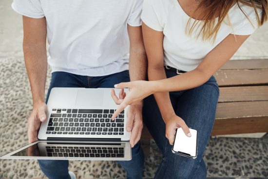 Dos personas buscando ejemplos en Google de estrategias de cross selling y up selling. 