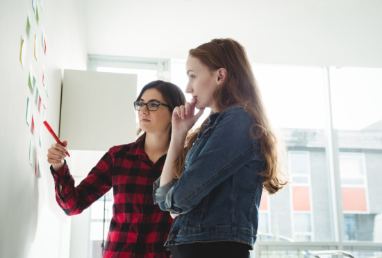 Dos profesionales de marketing decidiendo cómo crearán su comunicación de marketing integrada.